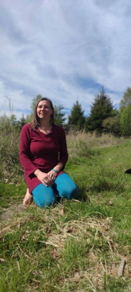 Carla Büscher kniend in der Natur als Bild für emotionale Muster und intuitive Arbeit